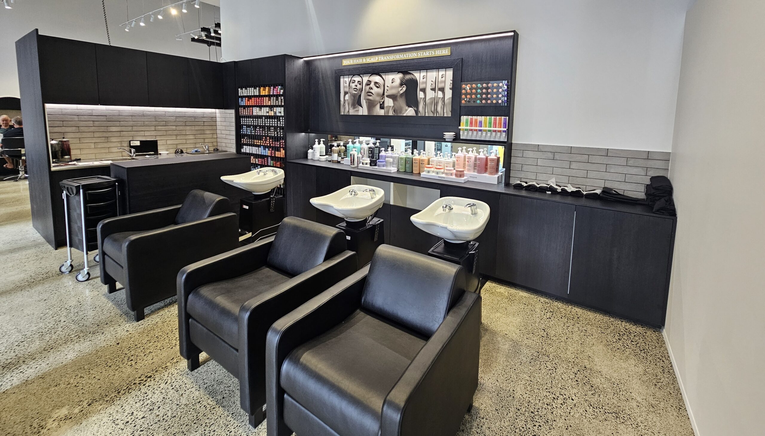 Modern salon shampoo basins with sleek black chairs at Rodney Wayne Commercial Bay.